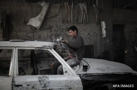 Twelve-year-old Palestinian boy Saher Totah works in a car workshop in Gaza City on April 7, 2014. There are about 65,000 working children in the Palestinian territories, accounting for 6% of all children at 5-14, accord...
