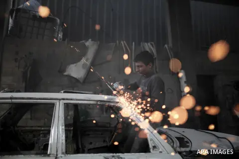 Twelve-year-old Palestinian boy Saher Totah works in a car workshop in Gaza City on April 7, 2014. There are about 65,000 working children in the Palestinian territories, accounting for 6% of all children at 5-14, accord...