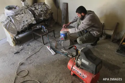 Palestinian Mahmoud Soboh, 28, works on a machine to extract fuel from plastic at a workshop in his house in Nuseirat refugee camp, central Gaza Strip, April 9, 2014. Soboh succeeded in production of fuel oil by the ther...