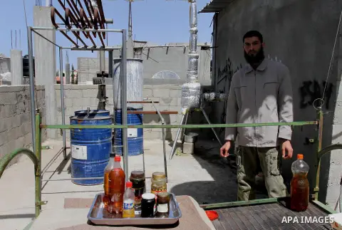 Palestinian Mahmoud Soboh, 28, works on a machine to extract fuel from plastic at a workshop in his house in Nuseirat refugee camp, central Gaza Strip, April 9, 2014. Soboh succeeded in production of fuel oil by the ther...
