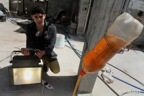 Palestinian Abdullah Soboh, 20, works on a machine to extract fuel from plastic at a workshop in his house in Nuseirat refugee camp, central Gaza Strip, April 9, 2014. Soboh succeeded in production of fuel oil by the the...