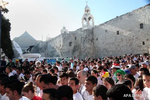 Participants run next to the Church of Nativity during the second Palestine Marathon in the West Bank town of Bethlehem April 11, 2014. About 2,500 runners participated in the marathon this year, Palestinian officials sa...