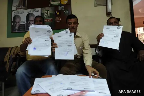 Supporters of Egyptian presidential hopeful, leftist, Hamdeen Sabahi, hold their authorization signatures for the nomination process at a registration office, in Beni Suef southern Cairo, April 11, 2014. Sabahi, who took...