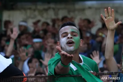 Palestinian fans chant and cheer during the final soccer match of Rafah team against Shija'a in a local competition, at al-Yarmouk stadium in Gaza City April 11, 2014. Photo by Mohammed Asad