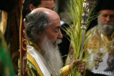 Orthodox Patriarch of Jerusalem Kiriws kiriws Theophilos III carries palm branches during the Palm Sunday celebrations at the Church of the Holy Sepulchre in Jerusalem's Old City on April 13, 2014. The ceremony is a land...