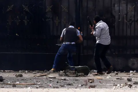 Armed plainclothes policemen try to enter the gate of Ain Shams University during clashes with students who are supporters of the Muslim Brotherhood and ousted President Mohamed Mursi, following a protest against former...
