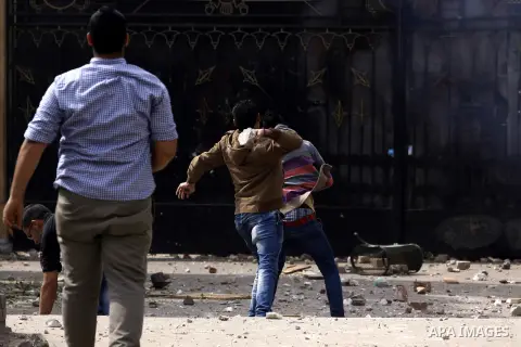 Egyptian youth throw stones towards students of who are supporters of the Muslim Brotherhood and ousted President Mohamed Mursi, during clashes following a protest against former army chief Abdel-Fattah al-Sisi's decisio...