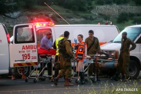 Israeli police and medical personnel load the body of an Israeli into the back of an ambulance at the scene of a shooting near the southern West Bank city of Hebron on April 14, 2014. An Israeli spokesman said that "fire...