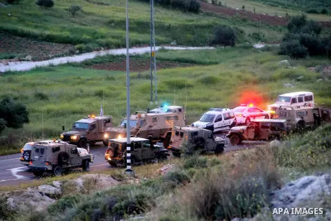 Israeli police, medical personnel and soldiers inspect the scene of a shooting near the southern West Bank city of Hebron on April 14, 2014. An Israeli spokesman said that "fire was opened at Israeli civilian vehicles on...
