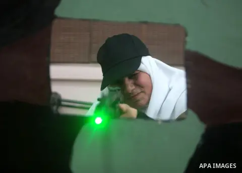 Female member of Palestinian security forces shoots during a target shooting session using makeshift laser guns at the police training headquarters in Gaza City, on April 16, 2014. Photo by Yasser Qudih