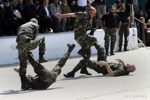 Members of national Palestinian security forces demonstrate their skills at a scene simulating breaking into an Israeli army post during a graduation ceremony in Gaza City April 17, 2014. Photo by Mohammed Asad