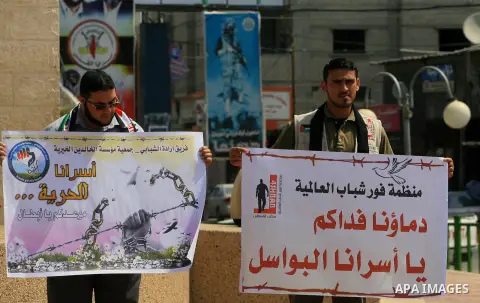 Palestinians hold banners in a rally marking Palestinian Prisoner Day, in Rafah in southern Gaza strip April 17, 2014. Israel holds some 5,000 Palestinians it accuses of committing or planning violence against it. Photo...