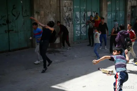 Young Palestinians throw stones at Israeli security forces during clashes following a rally marking Palestinian Prisoner Day in the West Bank city of Hebron April 17, 2014. Thousands of Palestinians across the West Bank...