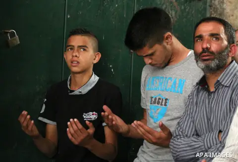 Palestinian muslims pray in front of Israeli policemen (not seen) as they prevent them from entering the Al-Aqsa mosque compound, in the Old City of Jerusalem on April 18, 2014. Israeli authorities on Friday prevented Pa...
