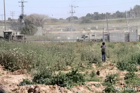 A Palestinian photographer takes photos in front of Israeli security forces during a demonstration in solidarity with prisoners held in Israeli jails, near Nahal Oz border crossing with Israel, east of Gaza City, on Apri...
