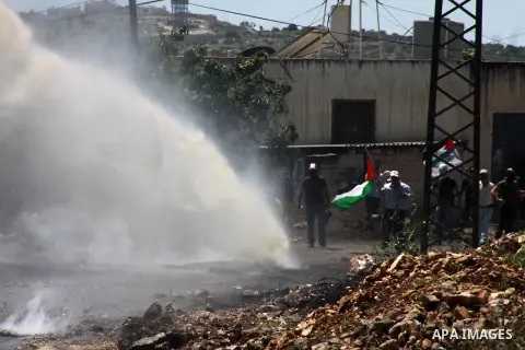 Members of the Israeli security forces spray sewage from a military vehicle during clashes following a weekly protest against the expropriation of Palestinian land by Israel in the village of Kfar Qaddum, near Nablus, in...