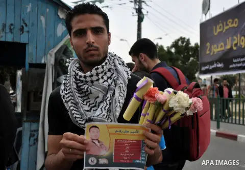 Palestinian youths distribute roses and pictures of Palestinian prisoners to mark the Palestinian Prisoner Day in Gaza City April 19, 2014. Photo by Mohammed Talatene