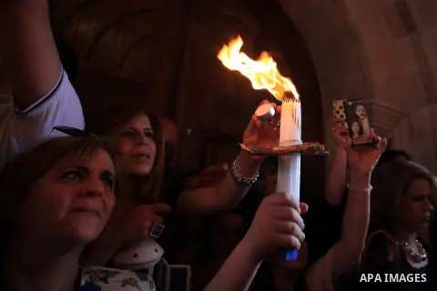 Christian pilgrims hold candles at the church of the Holy Sepulcher, traditionally believed to be the burial site of Jesus Christ, during the ceremony of the Holy Fire in Jerusalem's Old City, Saturday, April 19, 2014. T...