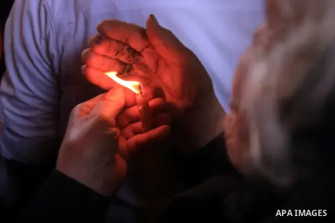 A worshipper holds candles as she takes part in the Christian Orthodox Holy Fire ceremony at the Church of the Holy Sepulchre in Jerusalem's Old City April 19, 2014. The "holy fire" was passed among worshippers outside t...
