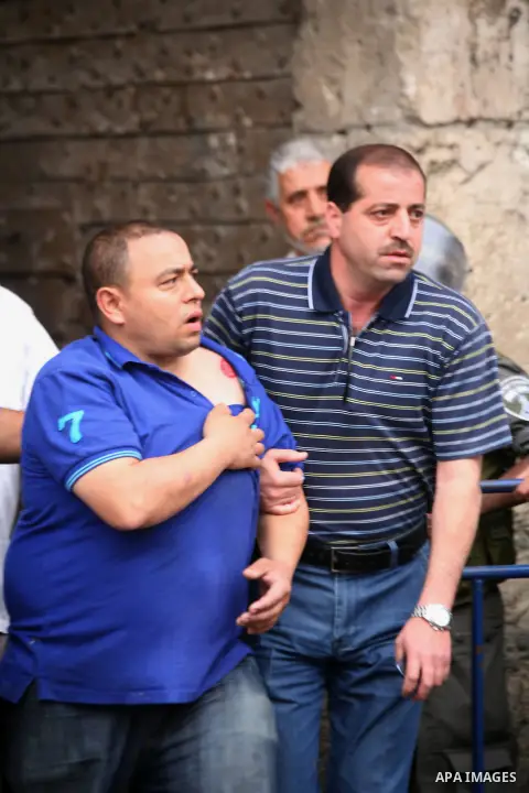 A Palestinian helps an injured man during clashes with Israeli policemen in Jerusalem's Old City, April 20, 2014. Dozens of Palestinian worshipers were wounded and 25 were detained after clashes broke outside the Al-Aqsa...