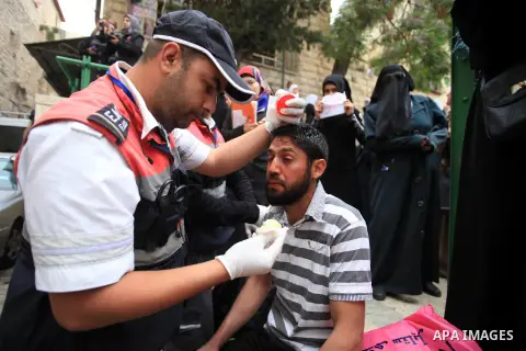 Medics treat a Palestinian man suffers from pepper spray during clashes with Israeli policemen in Jerusalem's Old City, April 20, 2014. Dozens of Palestinian worshipers were wounded and 25 were detained after clashes bro...