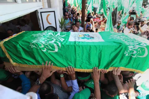 Palestinian mourners wave the green flag of the Islamist movement Hamas as they attend the funeral of two Hamas members, Adel and Imad Awadallah, killed in 1998, after Israel returned the remains of four Palestinians to...