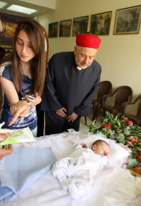 Man of the Samaritan Community looks as eight-day-old baby undergoes circumcision during a traditional circumcision ceremony atop Mount Gerizim, above the West Bank city of Nablus, May 05, 2014. The ritual of circumcisio...