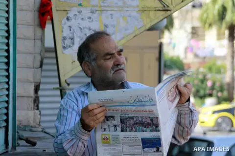 A Palestinian man reads a copy of the Palestine newspaper in the West Bank city of Nablus, on May 10, 2014. Palestinian government in Ramallah allowed the redistribution of a West Bank based Palestine newspaper in the We...