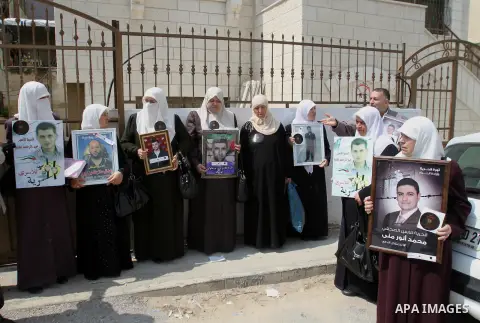 Palestinians take part in a protest demanding the release of their relatives prisoners on hunger strike held in Israeli jails, in front of the Red Cross office in the West Bank city of Nablus on May 11, 2014. About 5,000...