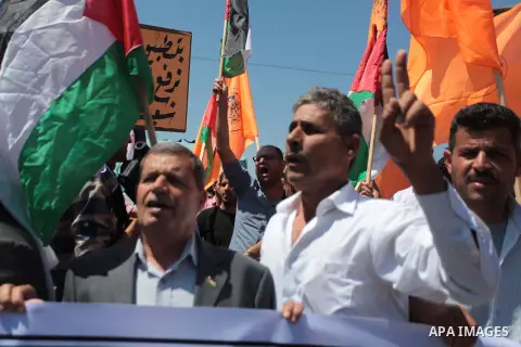 Palestinians shouts slogans and wave their national flag during a demonstration supporting a new attempt to reconcile the militant Islamist movement Hamas and the Palestine Liberation Organisation (PLO) in Gaza City on M...