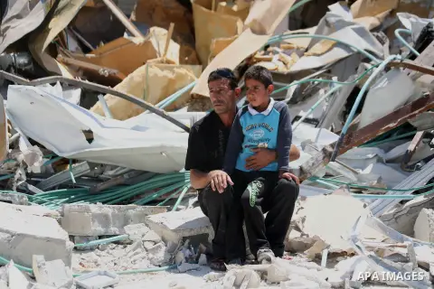 A Palestinian man with his son set on the rubbles of his house after demolish by Israeli municipality bulldozers under the pretext of building without permit, at Jabal al-Mukaber district, East Jerusalem May 14, 2014. Is...