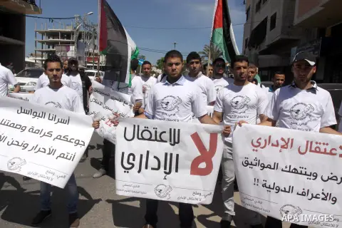 Palestinian protesters hold placards during a rally demanding the release of Palestinian prisoners on hunger strike held in Israeli jails, in front of the Red Cross office in Gaza City, 15 May 2014. According to reports,...