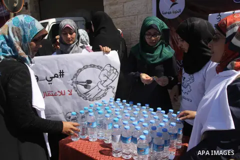 Palestinian protesters hold placards during a rally demanding the release of Palestinian prisoners on hunger strike held in Israeli jails, in front of the Red Cross office in Gaza City, 15 May 2014. According to reports,...