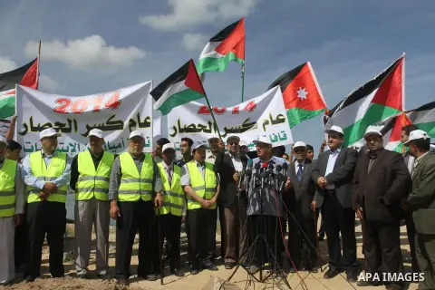 Palestinians hold banners and Palestine flags during a protest against the blockade on Gaza, at the seaport of Gaza City May 19, 2014. Israel imposed a blockade on Gaza in 2007 after Islamist group Hamas seized control o...
