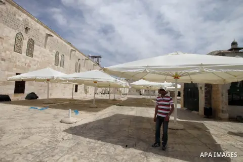 Palestinian workers set up sunshades at the al-Aqsa mosque compound in preparation for receive the summer season and holy month of Ramadan, in Jerusalem's old city on May 19, 2014. Photo by Saeed Qaq