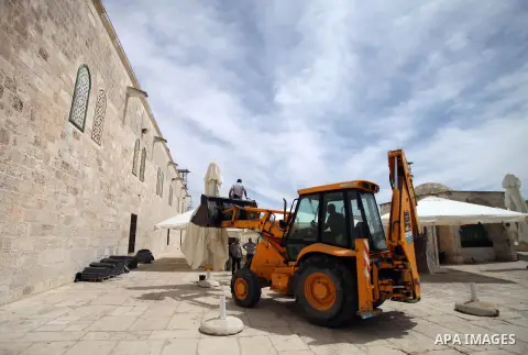 Palestinian workers set up sunshades at the al-Aqsa mosque compound in preparation for receive the summer season and holy month of Ramadan, in Jerusalem's old city on May 19, 2014. Photo by Saeed Qaq