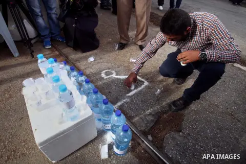 Palestinians display water bottle with a Arabic writting which reads: "water and salt" during a protest calling for the end of administrative detention, outside the Red Cross headquarter in Jerusalem on May 20, 2014 and...