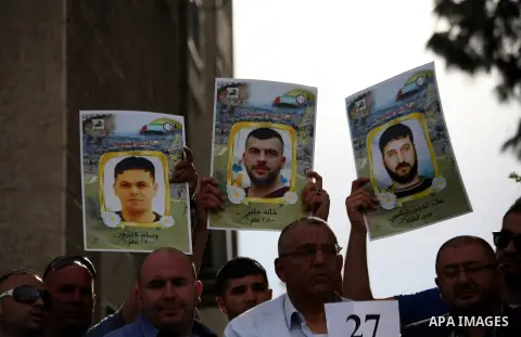 Palestinians hold placards during a protest calling for the end of administrative detention, outside the Red Cross headquarter in Jerusalem on May 20, 2014 and to express solidarity with Palestinian prisoners on hunger s...
