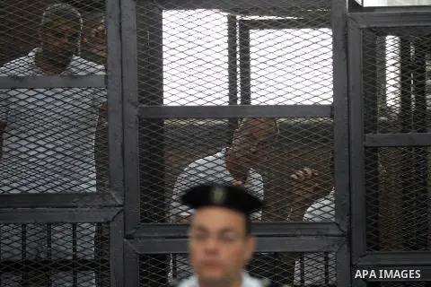 Defendants in the Marriott terror cell case in Cairo stand in cages in an Egyptian courtroom, in Cairo on May 22, 2014. A total of 20 defendants in the case are charged with harming Egypt's national interests by spreadin...