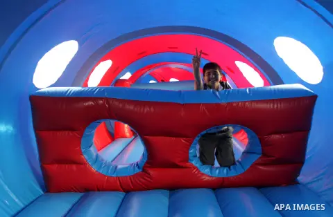 A Palestinian boy flashes victory sign as he plays on a huge water slide at Aqua Park, in Gaza City May 22, 2014. Photo by Mohammed Asad