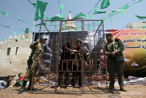 Palestinians men dressed in Israeli soldiers and prisoners uniforms are seen during a performance scene in a protest to express solidarity with Palestinian prisoners on hunger strike in Israeli jails, in Khan Younis in t...