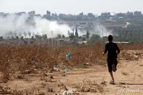 A Palestinian protester run for cover during clashes with Israeli security forces following a protest to show solidarity with Palestinian prisoners held in Israeli jails