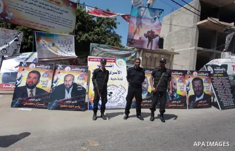 Palestinian policemen stand guard during a protest to solidarity with Palestinian prisoners held in Israeli jails, in front of Red Cross office in Gaza city May 24, 2014. Some 120 Palestinians jailed without trial in Isr...