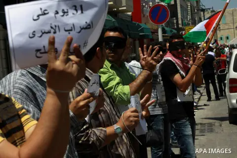 Palestinians take part a protest to solidarity with Palestinian prisoners held in Israeli jails, in the West Bank city of Tulkarem on May 24, 2014. Some 120 Palestinians jailed without trial in Israel have been on an ope...