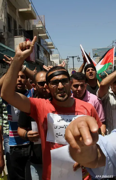 Palestinians take part a protest to solidarity with Palestinian prisoners held in Israeli jails, in the West Bank city of Tulkarem on May 24, 2014. Some 120 Palestinians jailed without trial in Israel have been on an ope...
