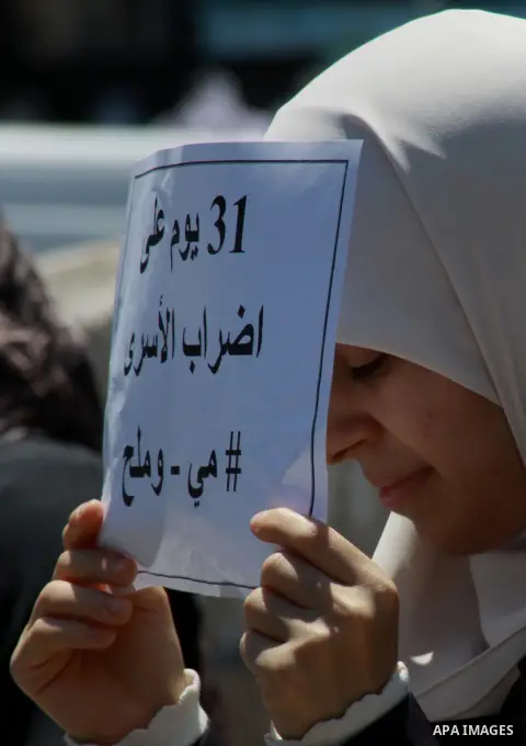 Palestinians take part a protest to solidarity with Palestinian prisoners held in Israeli jails, in the West Bank city of Tulkarem on May 24, 2014. Some 120 Palestinians jailed without trial in Israel have been on an ope...