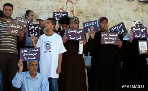 Palestinian protesters hold placards during a protest to solidarity with Palestinian prisoners held in Israeli jails, at Damascus Gate in Jerusalem's Old City on May 24, 2014. Some 120 Palestinians jailed without trial i...