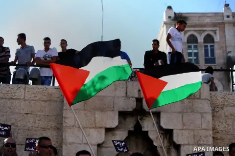 Palestinian protesters hold national flags during a protest to solidarity with Palestinian prisoners held in Israeli jails, at Damascus Gate in Jerusalem's Old City on May 24, 2014. Some 120 Palestinians jailed without t...