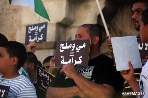 Palestinian protesters hold placards during a protest to solidarity with Palestinian prisoners held in Israeli jails, at Damascus Gate in Jerusalem's Old City on May 24, 2014. Some 120 Palestinians jailed without trial i...