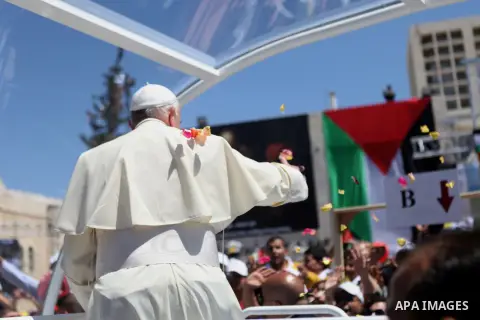 Pope Francis waves to the crowd as he arrives to give Mass at Manger Square, outside the Church of Nativity in the West Bank town of Bethlehem, May 25, 2014. Pope Francis on Sunday invited the Israeli and Palestinian pre...